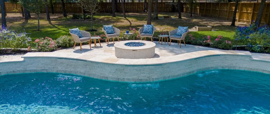 Beautiful fire pit with chairs along a pool in Kingwood, TX.