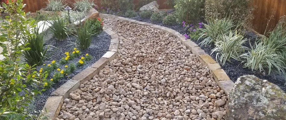 Dry creek bed running through a landscape in Kingwood, TX.