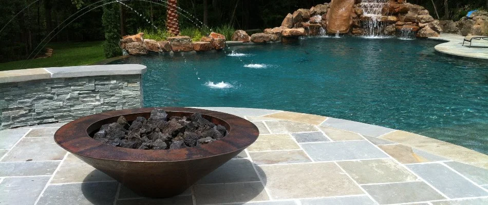 Fire bowl on pavers near a pool in Kingwood, TX.