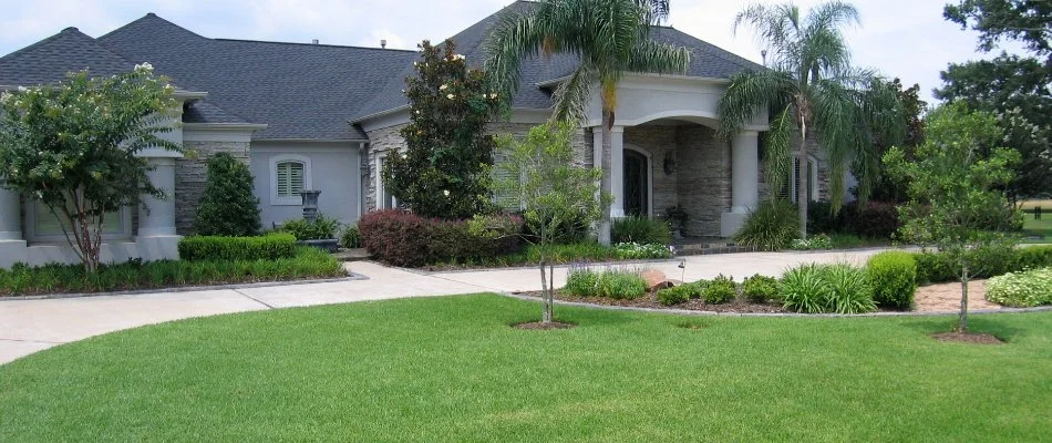 House in Kingwood, TX, with a pristine lawn and plantings.
