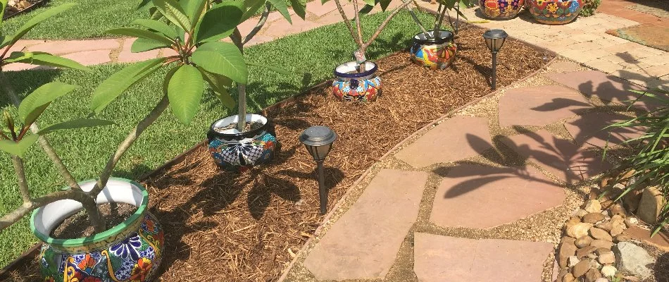 Mulch and potted plants along a walkway in Kingwood, TX.