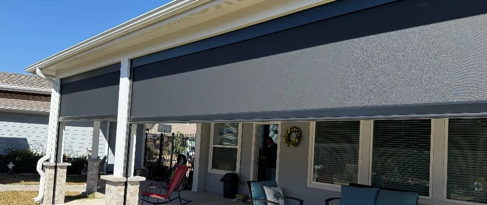 Patio area with a motorized screen partially down.