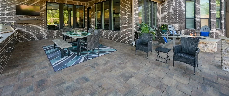 Paver patio in Kingwood, TX, with a table, chairs, and fire pit.