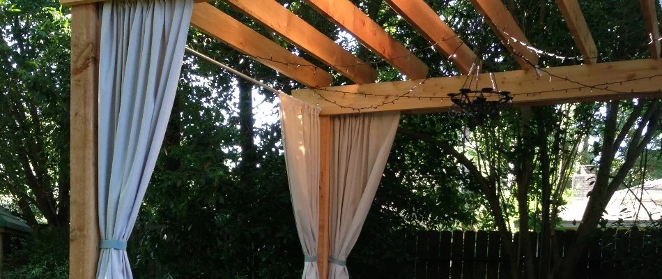 Wooden cabana with curtains.